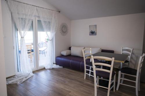 a living room with a table and chairs and a bed at Apartments Diva in Ston