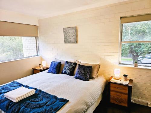 a bedroom with a large bed with blue pillows at The Parks Rosalie 32 - 1BRM Unit with Parking in Perth