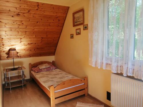 a small bedroom with a bed and a window at Dom na wzgórzu in Kiczora