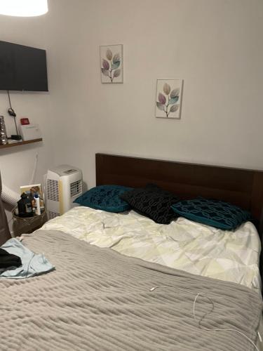 1 cama no hecha en un dormitorio junto a una TV en keiny apartamento, en Getafe