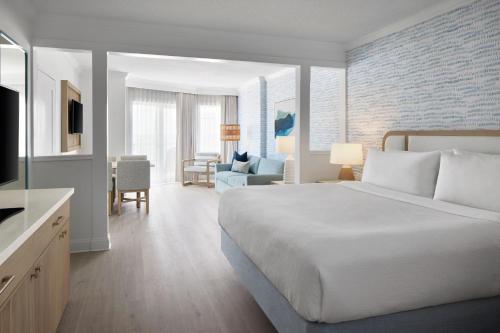 ベサニービーチにあるBethany Beach Ocean Suites Residence Inn by Marriottのベッドルーム(大型ベッド1台付)、リビングルームが備わります。