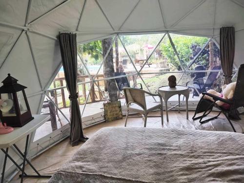 a bedroom with a large tent with a table and chairs at Eco Glamping Treehouses Closest Resort To All Tourist Attractions in Balilihan