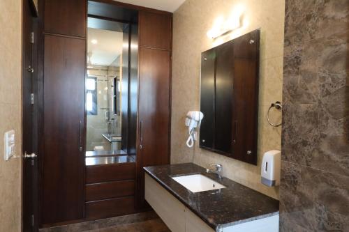 a bathroom with a sink and a mirror at Ahuja Residency City Centre in Gurgaon