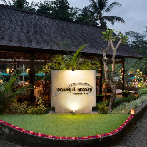 a sign in front of a resort with a lawn at The Samaya Ubud in Ubud