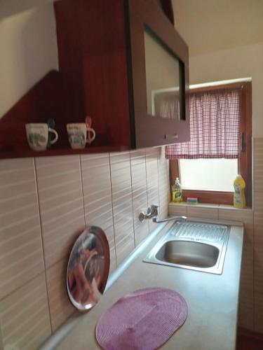 una pequeña cocina con lavabo y espejo en Kolibica en Mitrovac