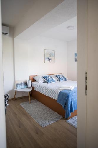 a bedroom with a bed and a white wall at Apartments Diva in Ston