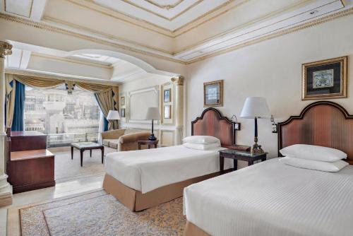 a bedroom with two beds and a living room at InterContinental Dar Al Tawhid Makkah by IHG in Makkah