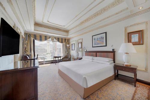 a bedroom with a large bed and a television at InterContinental Dar Al Tawhid Makkah by IHG in Makkah