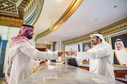 two men shaking hands at a table in a mosque at InterContinental Dar Al Tawhid Makkah by IHG in Makkah