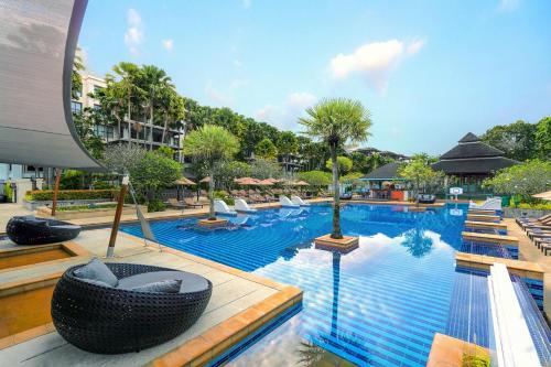 a pool at a resort with lounge chairs at Marriott's Mai Khao Resort - Phuket in Mai Khao Beach