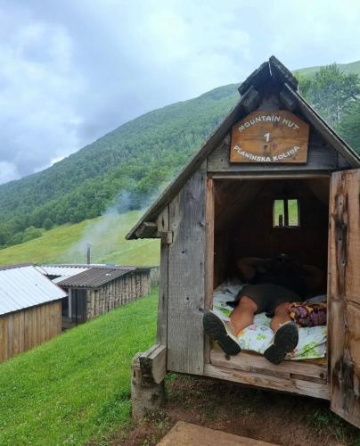 a person laying in a bed in a dog house at Katun Lanista-Kolibe Bogavac in Mojkovac