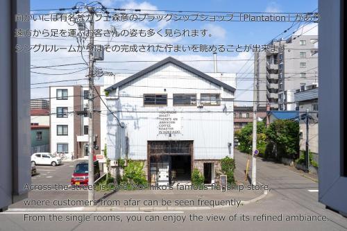 a building on the side of a street with writing on it at BEACH AND FIELD INN in Sapporo