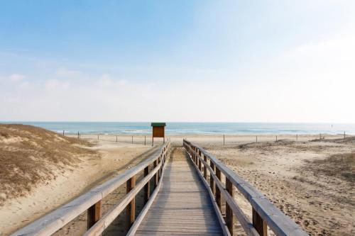 a wooden boardwalk leading to the beach at Villa Kara in Lido degli Scacchi