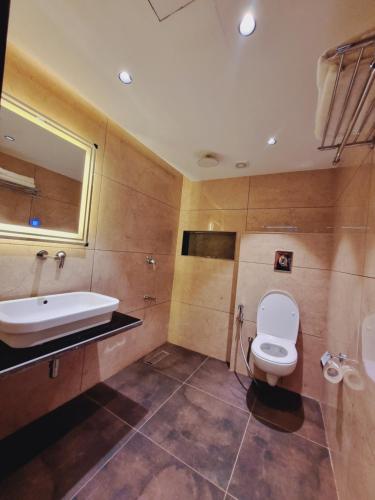 a bathroom with a toilet and a sink and a tub at White Water Resorts in Pahalgām