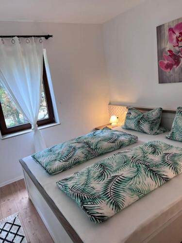 1 dormitorio con 2 camas y ventana en Apartment Mahira im Luftkurort Schindeldorf, en Stromberg