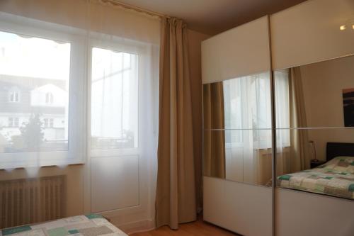 a bedroom with a large glass cabinet and a window at Bright, spacious apartment with a lovely terrace in the heart of Aachen in Aachen
