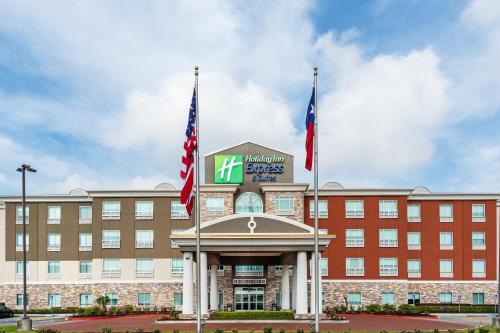 a hotel with two flags in front of a building at Holiday Inn Express Houston Space Center-Clear Lake by IHG in Webster