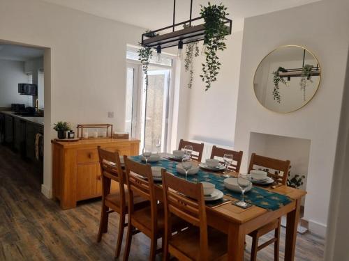a dining room with a table with chairs and a mirror at Home from home in Maryport in Maryport