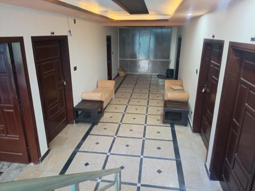 a hallway with chairs and tables in a room at Hotel Red Roof & Restaurant in Abbottābād