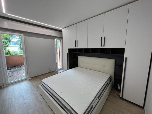 a bedroom with a bed and white cabinets and a window at Casa vacanze Collina d'oro in Montagnola