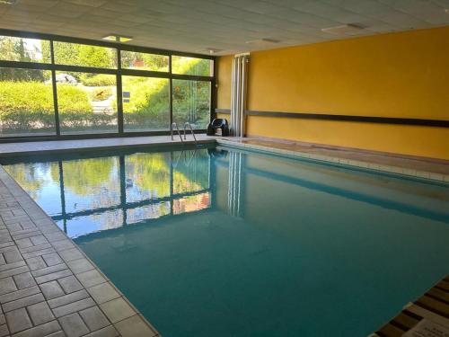 a swimming pool in a room with a large window at Casa vacanze Collina d'oro in Montagnola