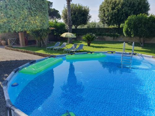 a large blue swimming pool with a slide in a yard at Appartamento Colle Mezzano in Cecina