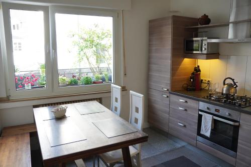 a kitchen with a table and a stove and a window at Bright, spacious apartment with a lovely terrace in the heart of Aachen in Aachen