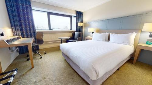 a hotel room with a large bed and a desk at Holiday Inn Cardiff City Centre by IHG in Cardiff