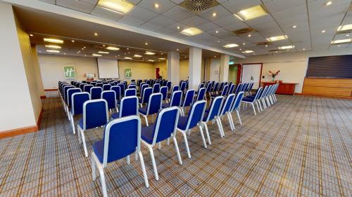 a room filled with blue chairs in a classroom at Holiday Inn Cardiff City Centre by IHG in Cardiff