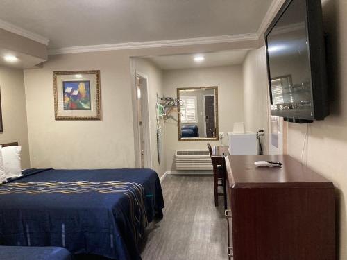 a hotel room with a bed and a desk in it at Little Boy Blue Motel in Anaheim