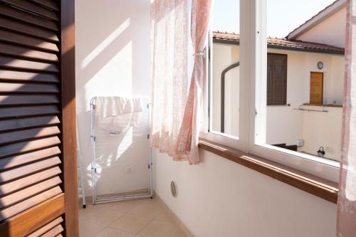 a hallway with an open window and a bathroom at Casa Le corti in Livorno