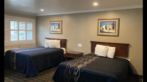 um quarto de hotel com duas camas e uma janela em Little Boy Blue Motel em Anaheim