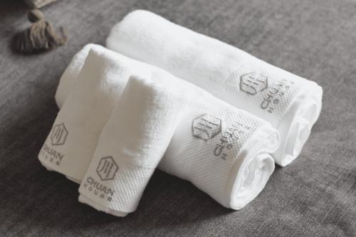 two white towels sitting on top of a table at Chuan House Nambaminami Hanazonocho in Osaka