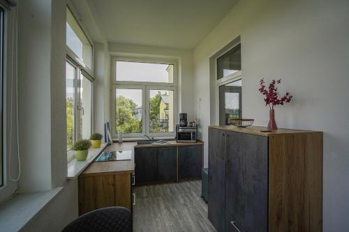 a room with a kitchen with a desk and windows at Ferienwohnung Weitblick in Naumburg