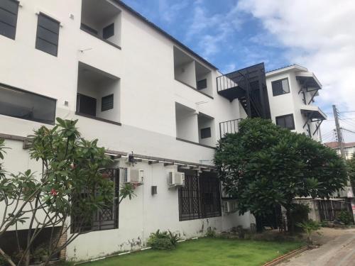 a white building with black windows and a yard at Mali's Room in Chiang Mai
