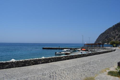 a beach with boats on it next to the water at Zorbas Studios in Agia Roumeli