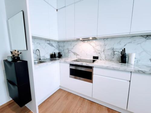 - une cuisine blanche avec des placards blancs et un évier dans l'établissement Black&White Studio, à Mons