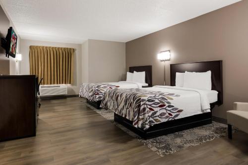 um quarto de hotel com duas camas e uma televisão em Red Roof Inn Hartford- New Britain em New Britain