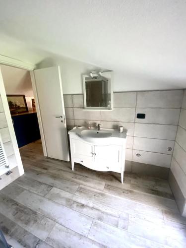 y baño con lavabo blanco y espejo. en La delizia della valle, 