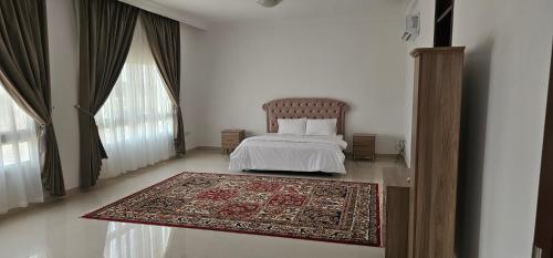 a bedroom with a bed and a rug on the floor at Luxury Garden Villas Complex in Salalah