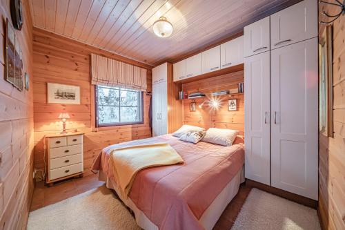 1 dormitorio con 1 cama en una habitación de madera en Levillas Sävelpolku 12B, en Levi