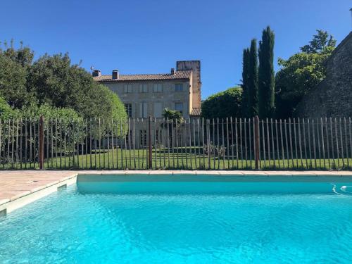 une piscine en face d'une clôture dans l'établissement Le Castellas, demeure historique, rénovée, piscine, à Collias