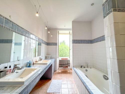 La grande salle de bains est pourvue de 2 lavabos et d'une baignoire. dans l'établissement Le Castellas, demeure historique, rénovée, piscine, à Collias