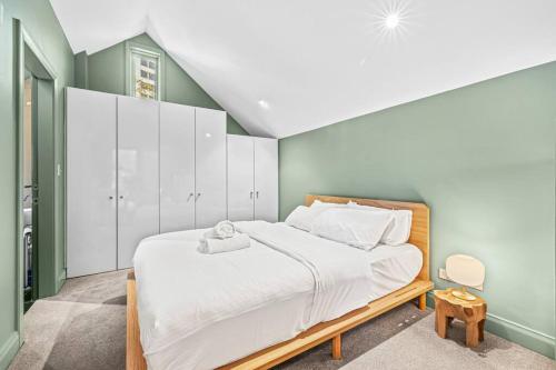 a bedroom with a large bed with white cabinets at Old Sydney Comfort Self- Catering in Sydney