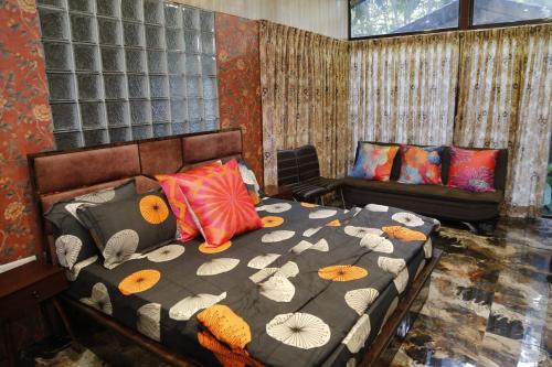 een slaapkamer met een bed en een bank bij Seaswan resort in Alibaug