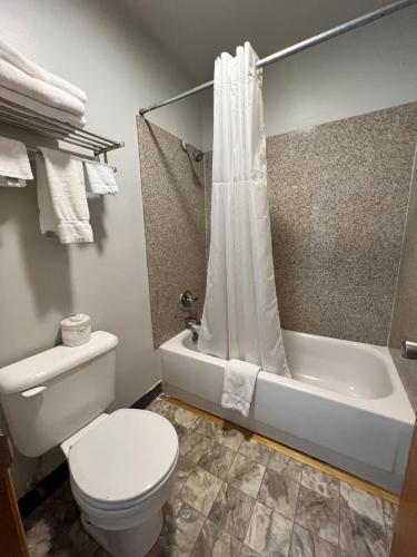 a bathroom with a white toilet and a bath tub at BIGGS NU-VU MOTEL in Biggs Junction