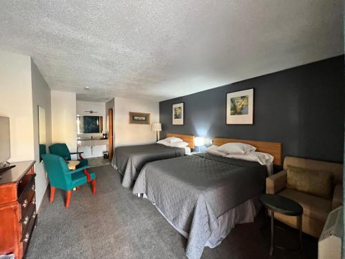 um quarto de hotel com duas camas e uma cadeira em BIGGS NU-VU MOTEL em Biggs Junction