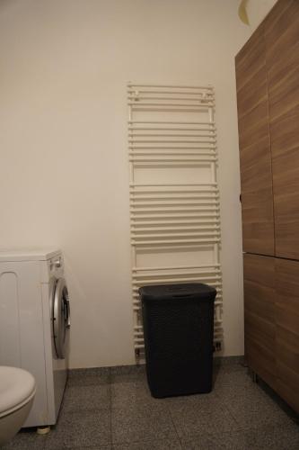 a bathroom with a toilet and a trash can at Bright, spacious apartment with a lovely terrace in the heart of Aachen in Aachen