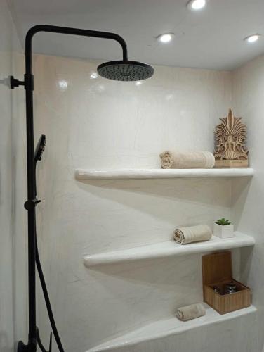 a bathroom with white shelves with towels on them at Villa Art Natalie in Kithnos