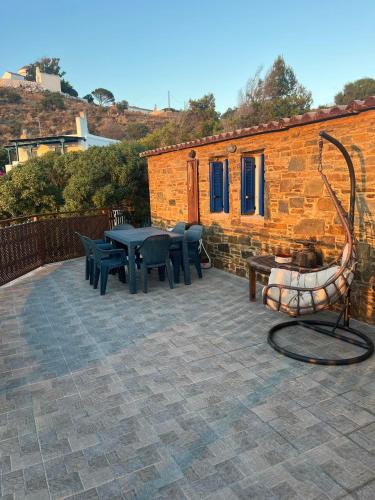 a patio with a table and chairs and a building at Villa Art Natalie in Kithnos